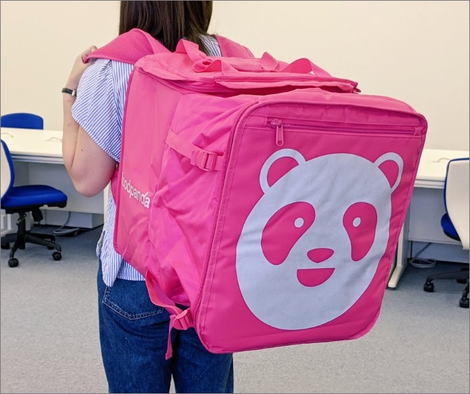 「Foodpanda」のデリバリーバッグを背負う姿